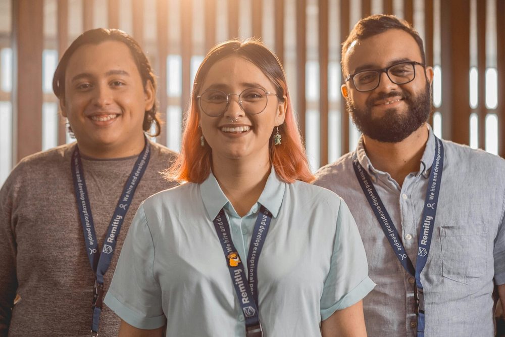Tre professionisti sorridenti con il badge al collo
